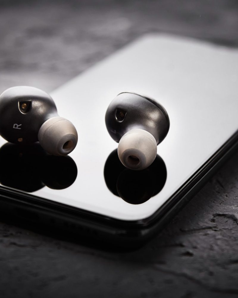 Wireless earphones on a smartphone. Bluetooth headphones for listen audio